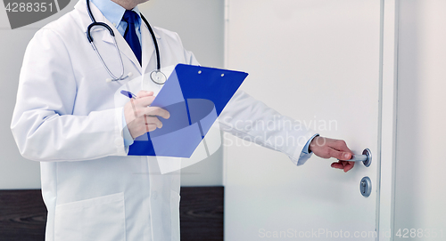 Image of close up of doctor with clipboard at hospital door