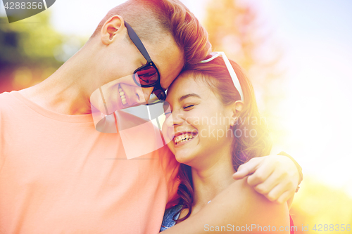 Image of happy teenage couple hugging at summer