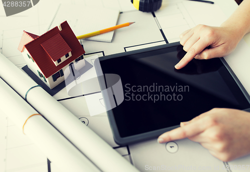 Image of close up of hand with blueprint and tablet pc