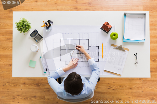 Image of architect with compass measuring blueprint