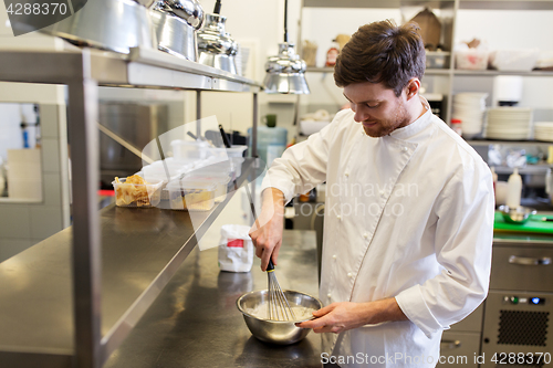 Image of happy male chef cooking food at restaurant kitchen