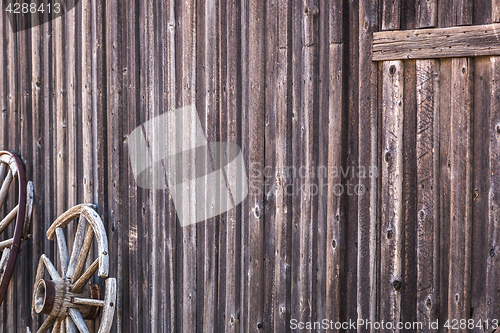 Image of Abstract of Vintage Antique Log Cabin Wall and Wagon Wheel.