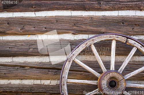 Image of Abstract of Vintage Antique Log Cabin Wall and Wagon Wheel.