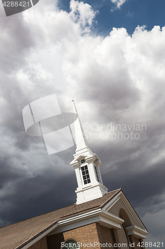 Image of Church Steeple Tower Below Ominous Stormy Thunderstorm Clouds.
