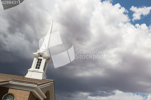 Image of Church Steeple Tower Below Ominous Stormy Thunderstorm Clouds.