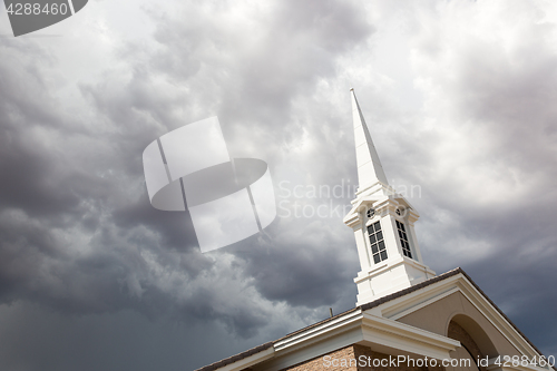 Image of Church Steeple Tower Below Ominous Stormy Thunderstorm Clouds.