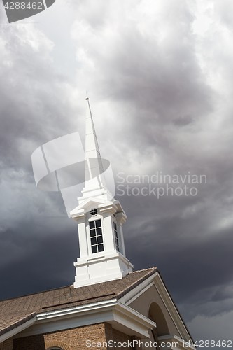 Image of Church Steeple Tower Below Ominous Stormy Thunderstorm Clouds.