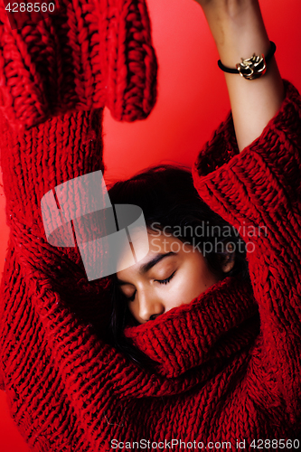 Image of young pretty indian mulatto girl in red sweater posing emotional, fashion hipster teenage, lifestyle people concept