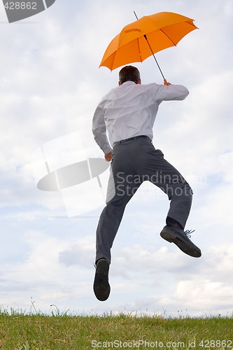 Image of Happy businessman with orange umbrella