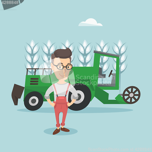 Image of Farmer standing with combine on background.