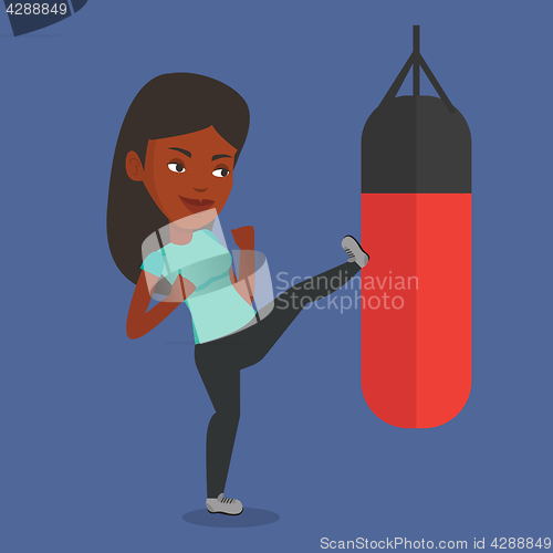 Image of Woman exercising with punching bag.