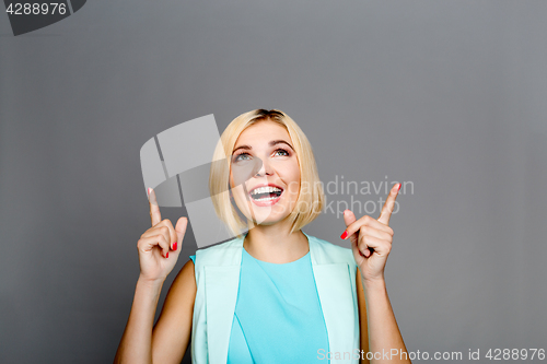 Image of Smiling blonde showing fingers upstairs