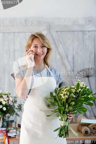 Image of Florist with phone and bouquet