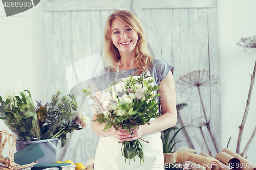 Image of Florists woman working at greenhouse.