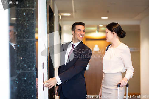 Image of business team with travel bags at hotel elevator