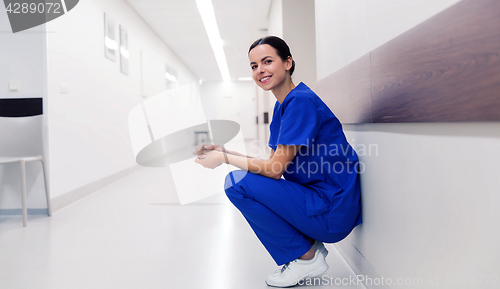 Image of happy doctor or nurse at hospital corridor