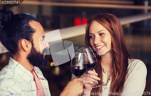Image of couple drinking red wine and clinking glasses