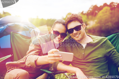 Image of couple of travelers taking selfie by smartphone