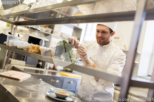 Image of happy male chef cooking at restaurant kitchen