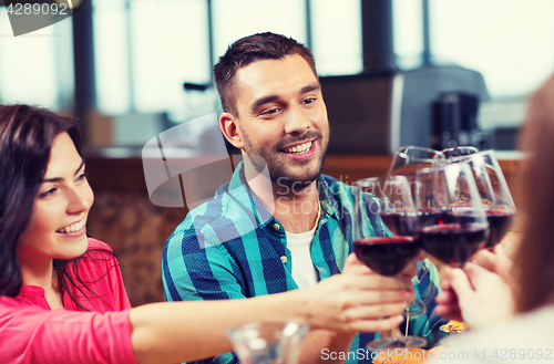 Image of friends clinking glasses of wine at restaurant