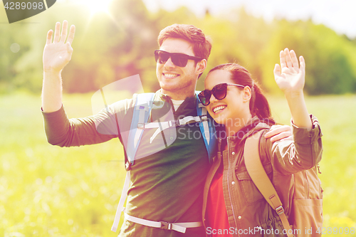 Image of happy couple with backpacks hiking outdoors