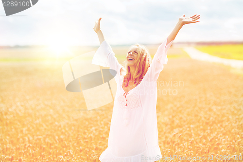 Image of smiling young woman in white dress on cereal field