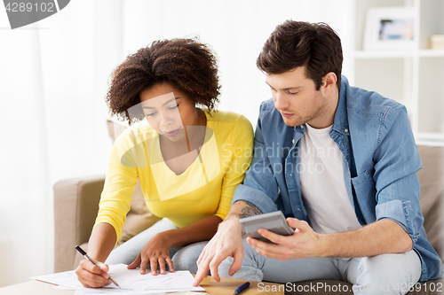 Image of couple with papers and calculator at home