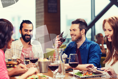 Image of friends dining and drinking wine at restaurant
