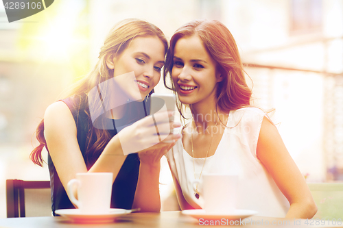 Image of young women with smartphone and coffee at cafe