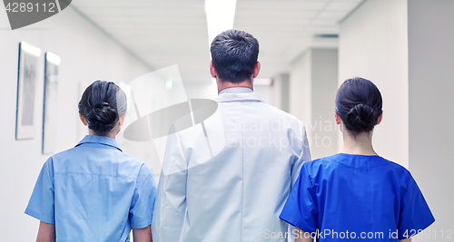 Image of group of medics or doctors walking along hospital