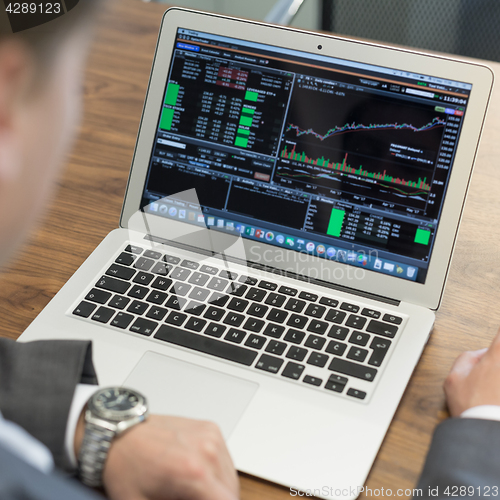 Image of Young businessman working with laptop, man\'s hands on notebook computer.