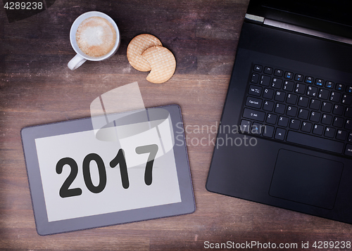Image of Tablet touch computer gadget on wooden table - 2017