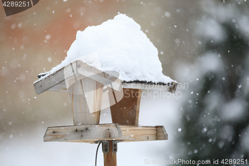 Image of simple bird feeder in winter garden