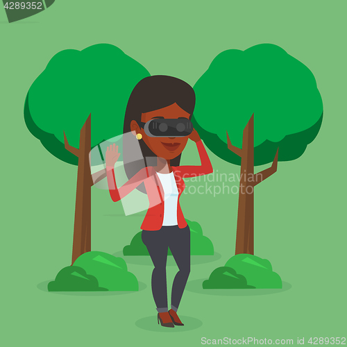 Image of Woman wearing virtual reality headset in the park.