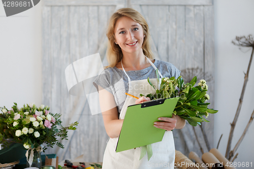 Image of Beautiful florist writes down orders