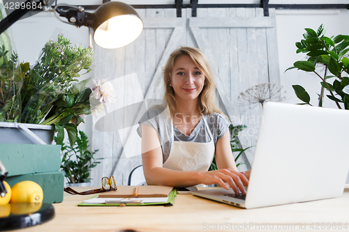 Image of Young woman florist at table