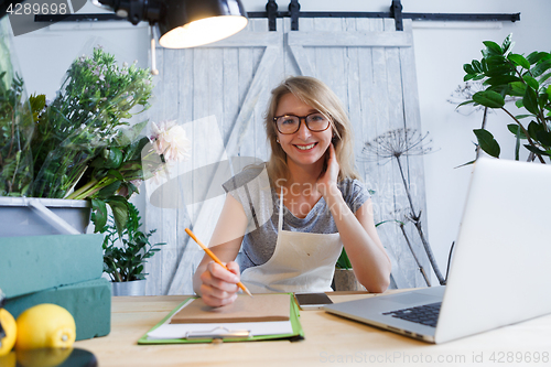 Image of Woman florist sitting at table