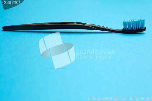 Image of Black toothbrush with blue bristle