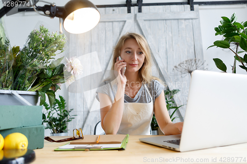 Image of Woman florist talking on phone