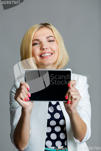 Image of Smiling young model holds tablet