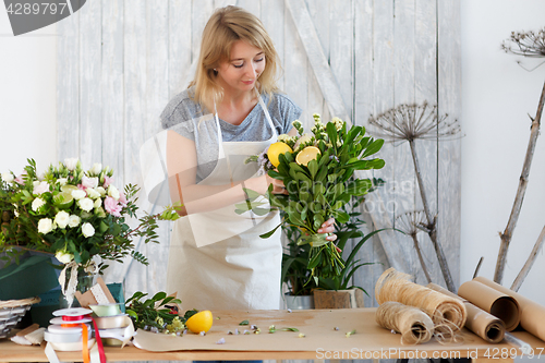 Image of Blonde composes bouquet with lemon