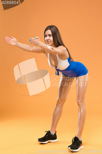 Image of Muscular young woman athlete posing at studio