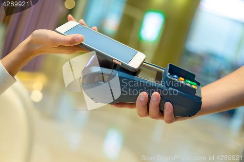 Image of Woman use of mobile phone to pay