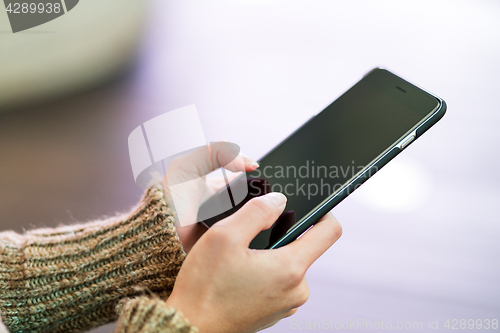 Image of Woman sending text message on cellphone