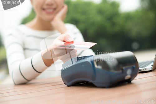 Image of Woman pay by mobile phone on pos machine