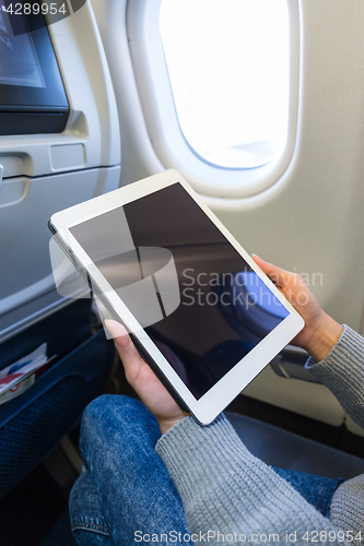 Image of Woman use of tablet pc inside aircraft