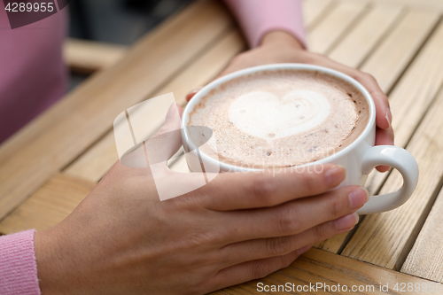 Image of Woman having coffee at outdoor cafe