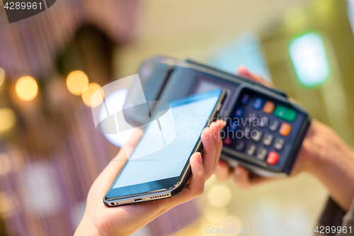 Image of Woman using mobile phone to pay