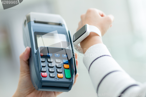 Image of Woman using smartwatch to pay the bill