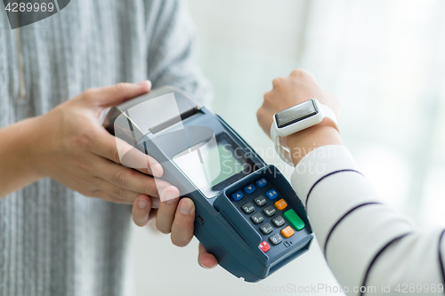 Image of Woman using cellphone for paying the bill